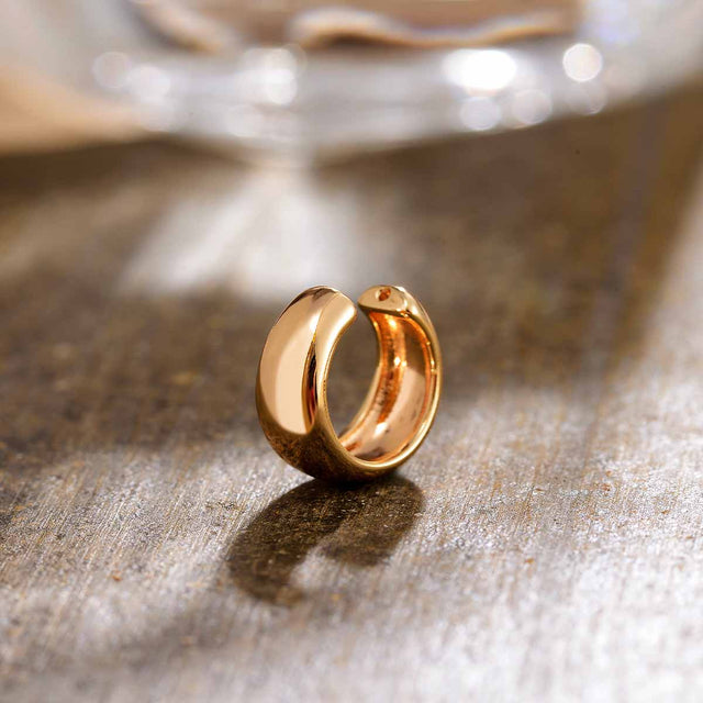 Close-up detail of Fettero® dome ear cuff, polished gold finish and smooth sculptural craftsmanship for women