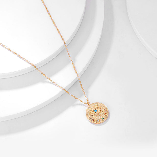 Close-up detail of Fettero® engraved evil eye pendant necklace, polished gold engraving and refined craftsmanship for women