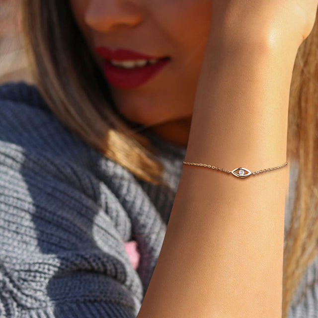 Model wearing Fettero® evil eye CZ gold chain bracelet for women, delicate everyday wear jewelry with symbolic charm