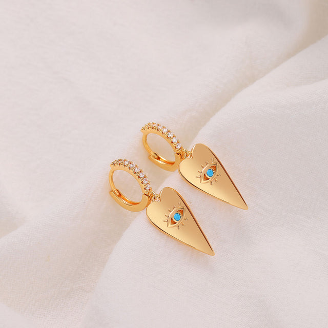 Close-up of Fettero® heart eye dangle earrings highlighting the heart motif and polished gold finish