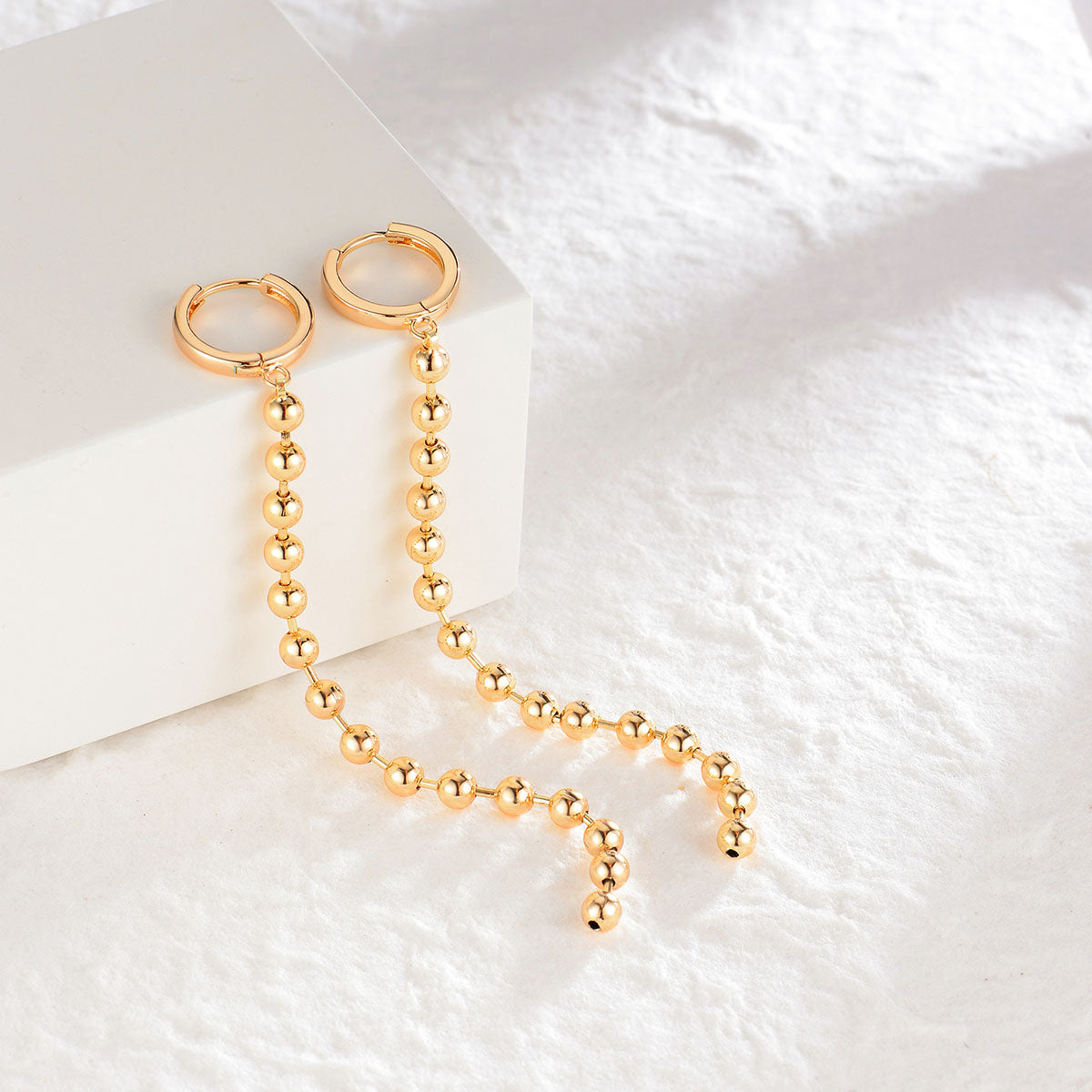 Close-up of Fettero® heart eye dangle earrings highlighting the heart motif and polished gold finish
