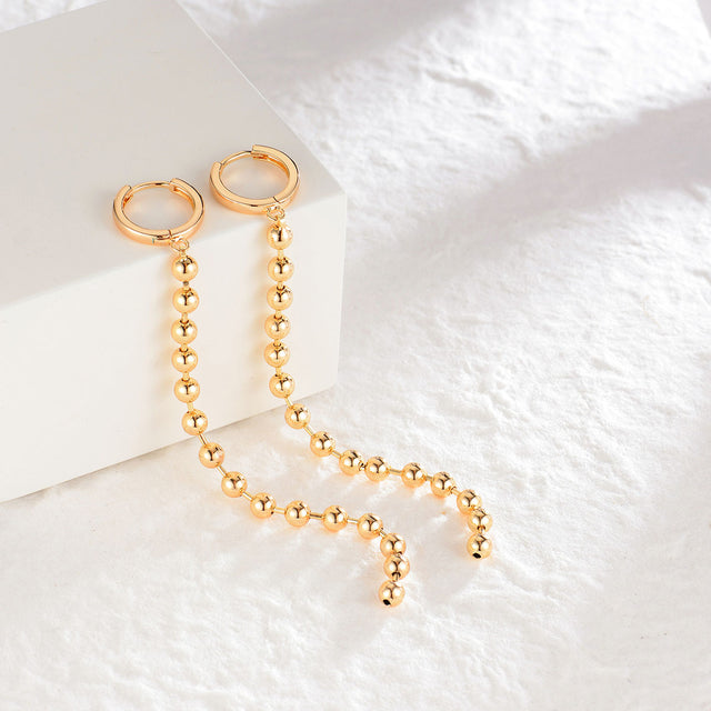 Close-up of Fettero® heart eye dangle earrings highlighting the heart motif and polished gold finish