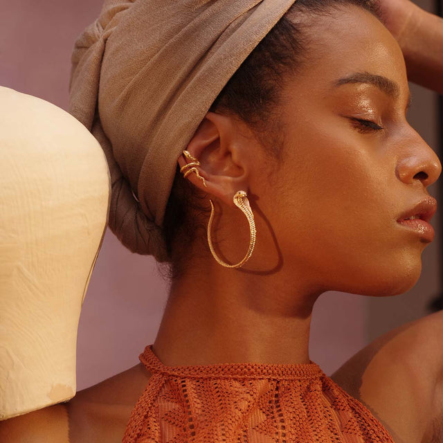 Model wearing Fettero® large snake hoop earrings in gold, statement earrings designed for everyday wear