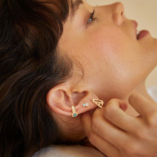Woman wearing mini diamond gold stud earrings by Fettero®, refined everyday jewelry with subtle sparkle
