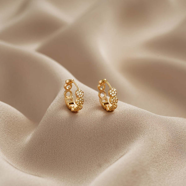 Close-up detail of Fettero® pavé CZ hoop earrings, sparkling cubic zirconia and polished gold finish for women