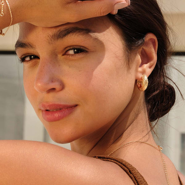 Fettero® serpentine chunky hoop earrings styled on model, gold hoop earrings for women and thoughtful gift choice