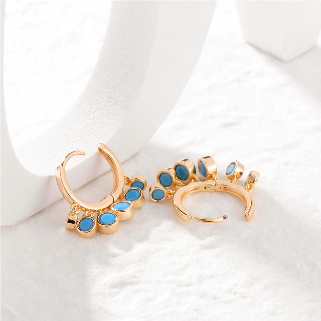 Model wearing Fettero® turquoise gold dangle huggie earrings for women, elegant everyday wear jewelry with colorful charm