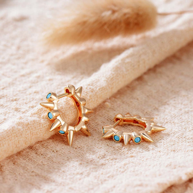 Close-up detail of Fettero® turquoise spike hoop earrings, polished gold finish with turquoise spike accents