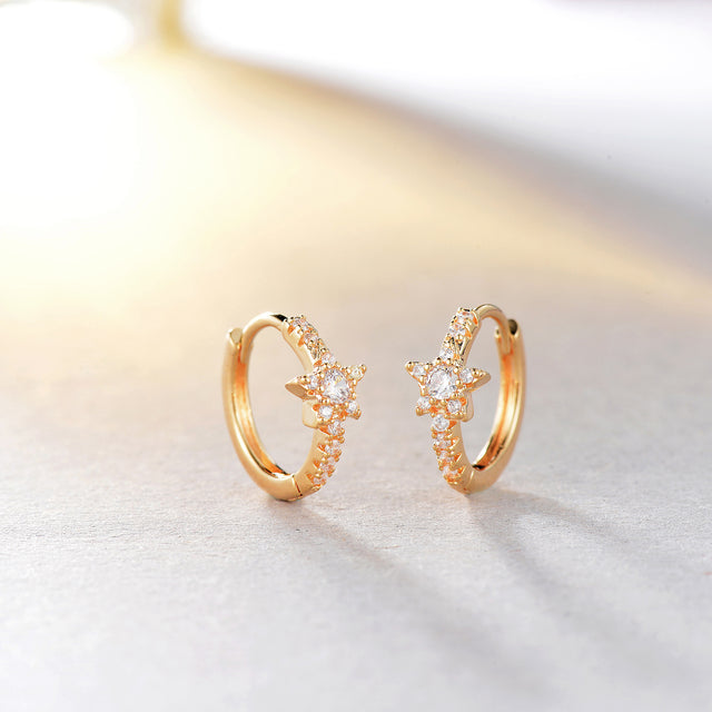 Close-up detail of Fettero® CZ star huggie earrings, polished gold finish and sparkling cubic zirconia for women