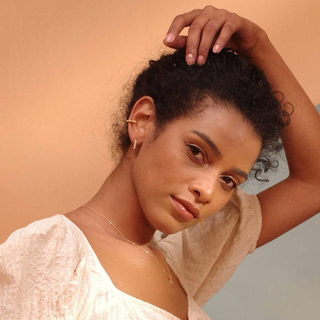 Fettero® CZ twisted huggie earrings styled on model, gold earrings for women perfect for everyday wear and gifting
