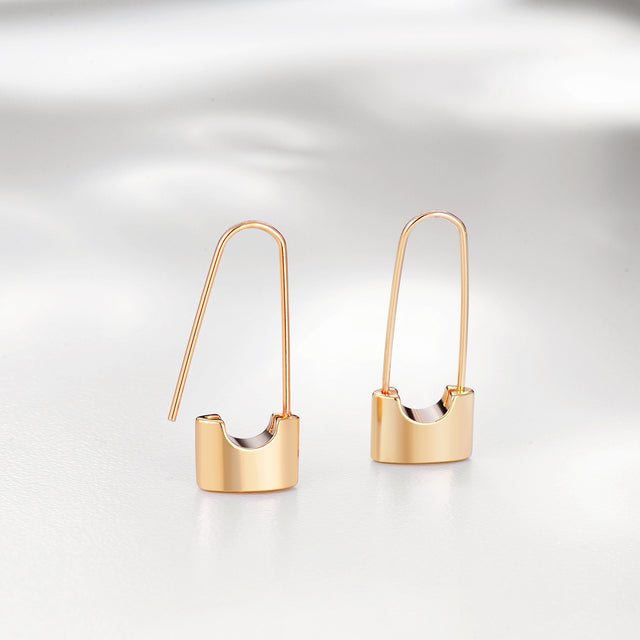 Close-up detail of Fettero® lock dangle earrings, polished gold lock charm and refined craftsmanship for women