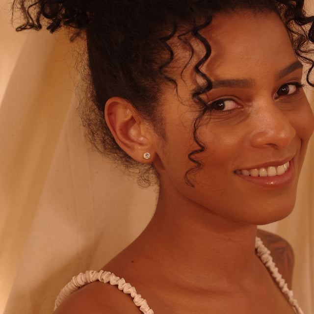 Woman wearing Fettero® mini donut studs, small gold stud earrings with a clean and modern everyday style