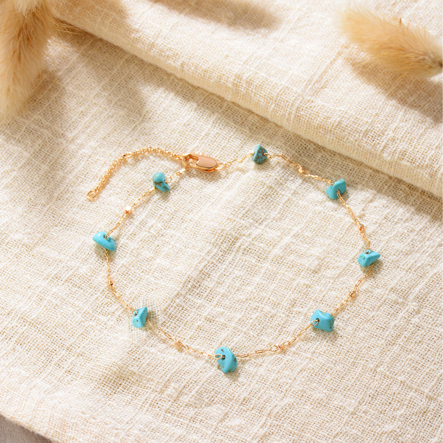 Close-up detail of Fettero® natural turquoise chain anklet, polished gold chain with genuine turquoise stones