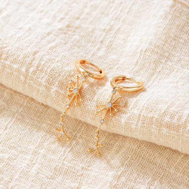 Close-up detail of Fettero® nebula dangle earrings, refined gold finish with celestial-inspired design