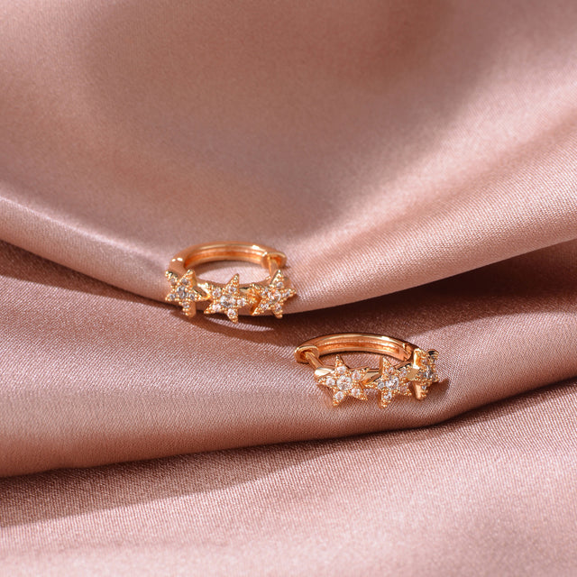 Close-up detail of Fettero® pavé star hoop earrings, sparkling cubic zirconia and polished gold finish for women